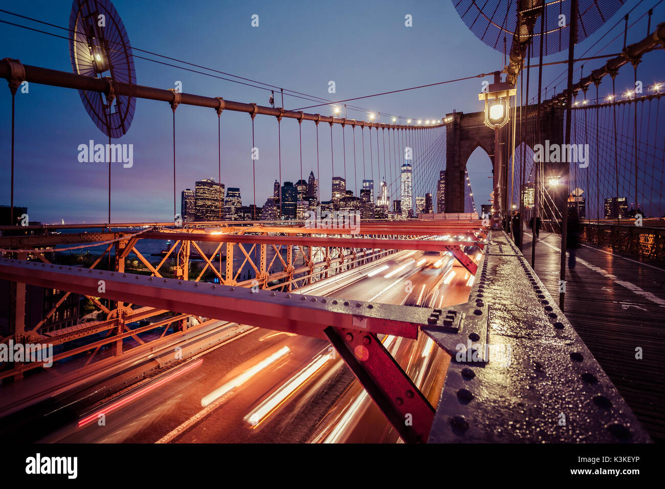 Der Verkehr auf der Brooklyn Bridge, regnerischen Abend, Wolkenkratzer und Skyline von Manhatten, New York, USA Stockfoto