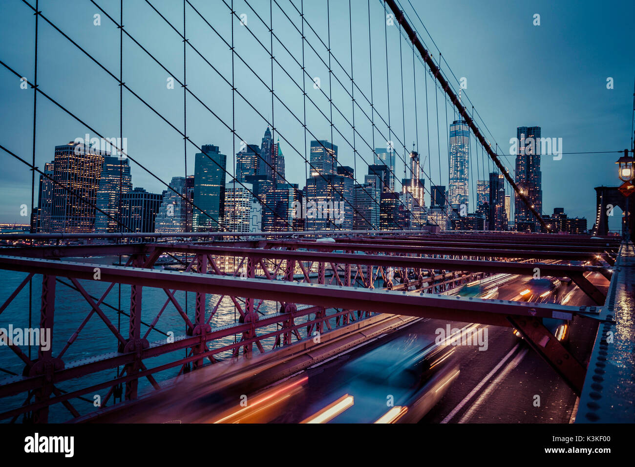 Der Verkehr auf der Brooklyn Bridge, regnerischen Abend, Wolkenkratzer und Skyline von Manhatten, New York, USA Stockfoto