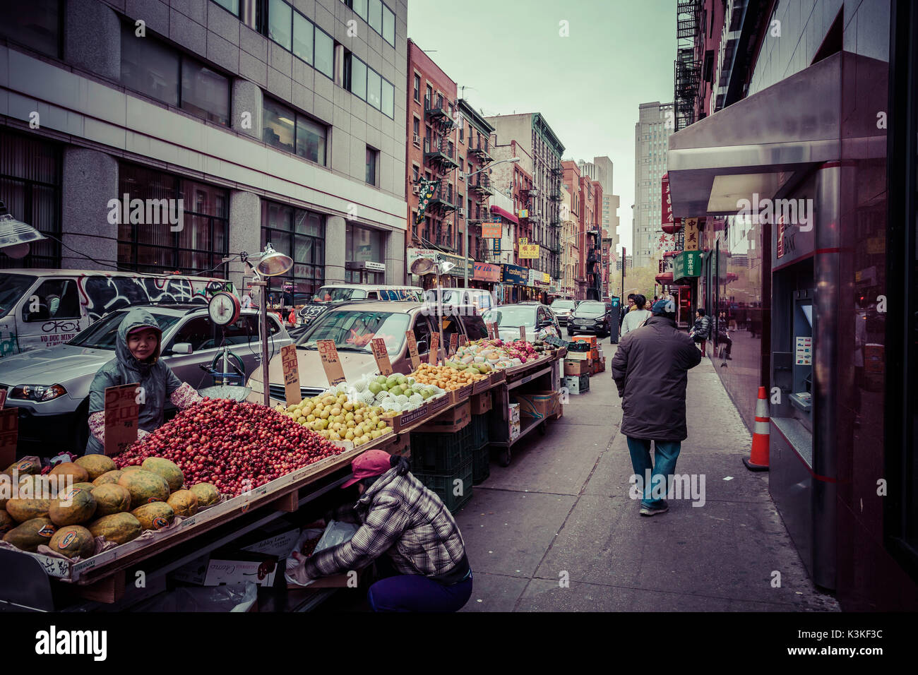 Eine Frucht Marktstand und Straßenbild mit Autos und Fußgängern in Chinatown, Manhatten, New York, USA Stockfoto