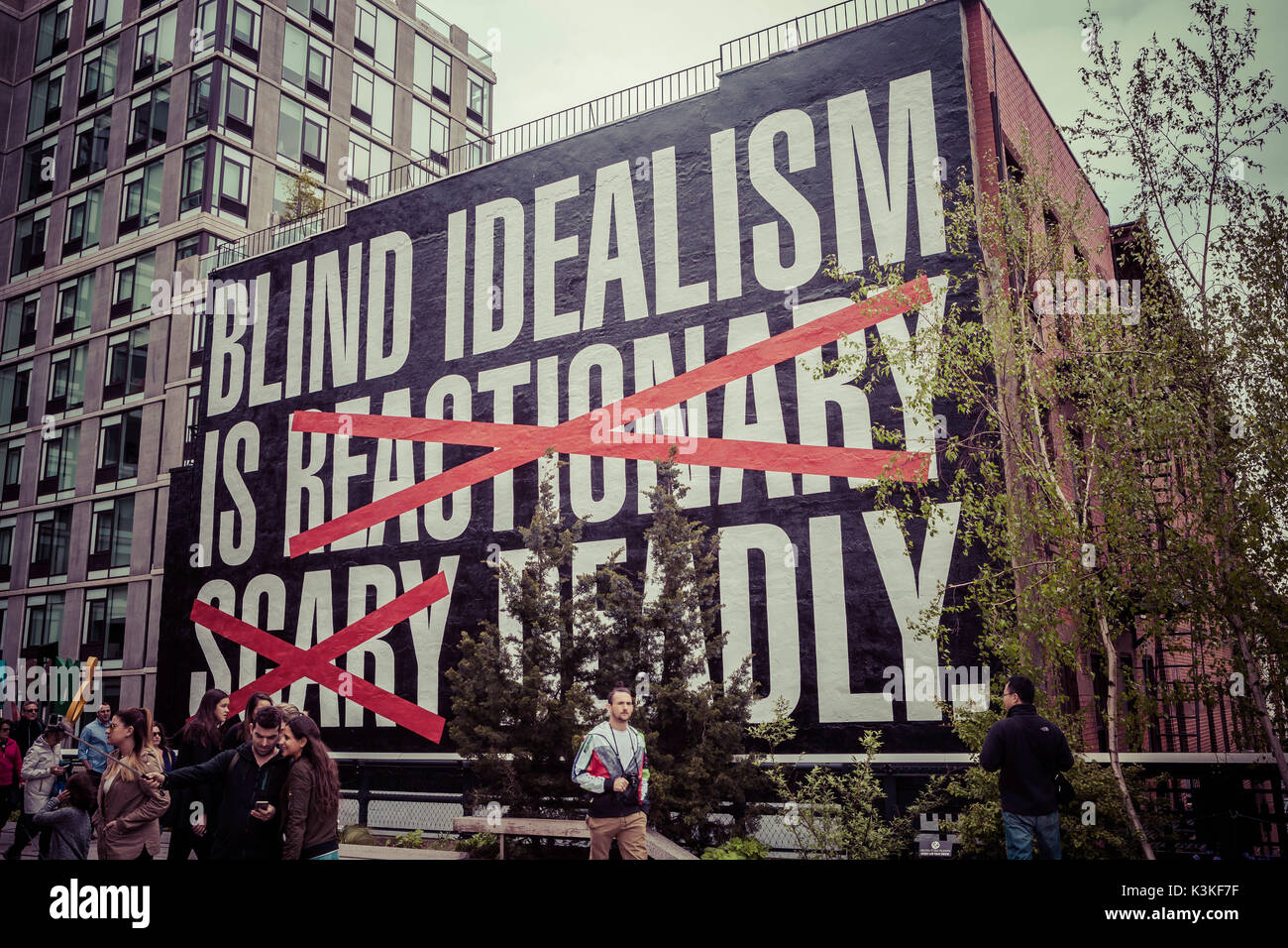 Plakat "blinden Idealismus ist reaktionär unheimlich tödlichen', die High Line ist ein öffentlicher Park auf einem historischen Freight rail line gebaut über den Straßen in die West Side von Manhattan erhöht. Chelsea, Art District, Touristenattraktion und Leben Linie von New York, Manhattan, USA Stockfoto
