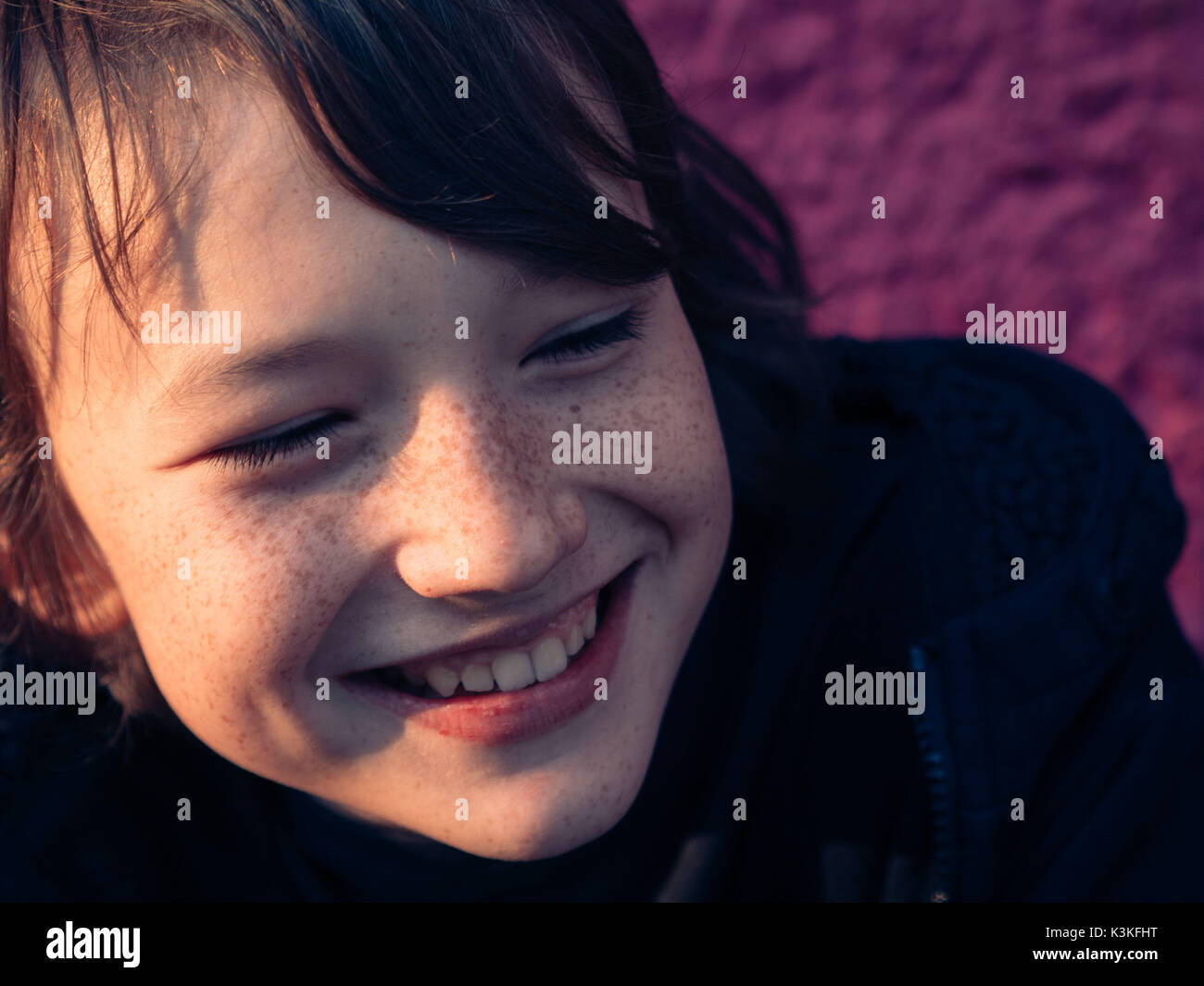 Porträt einer niedlichen happy Teenager Junge mit den Sommersprossen - rosa Hintergrund Stockfoto