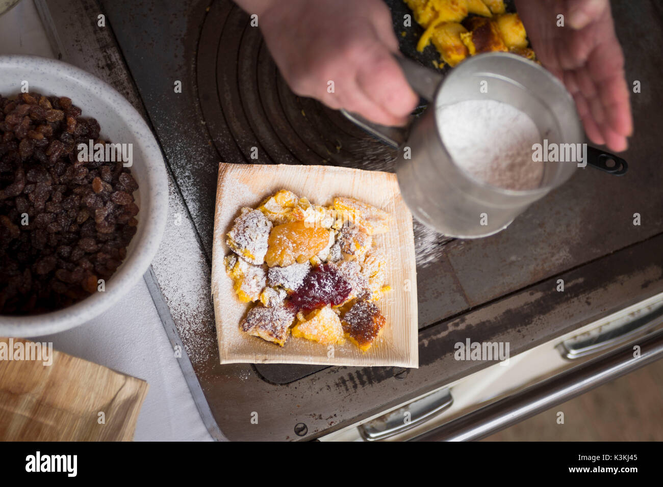 Eine Nahaufnahme von einem Koch spinkling Puderzucker über der Kaiserschmarrn, einem typischen Südtiroler Essen, Provinz Bozen, Südtirol, Trentino Alto Adige, Italien, Europa Stockfoto