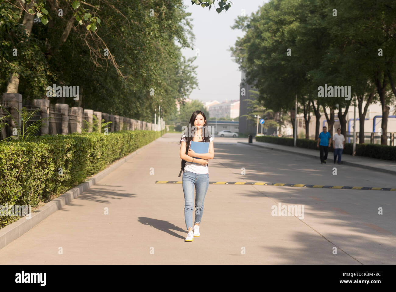 Mädchen Tragetasche Spaziergänge in Campus Park Stockfoto
