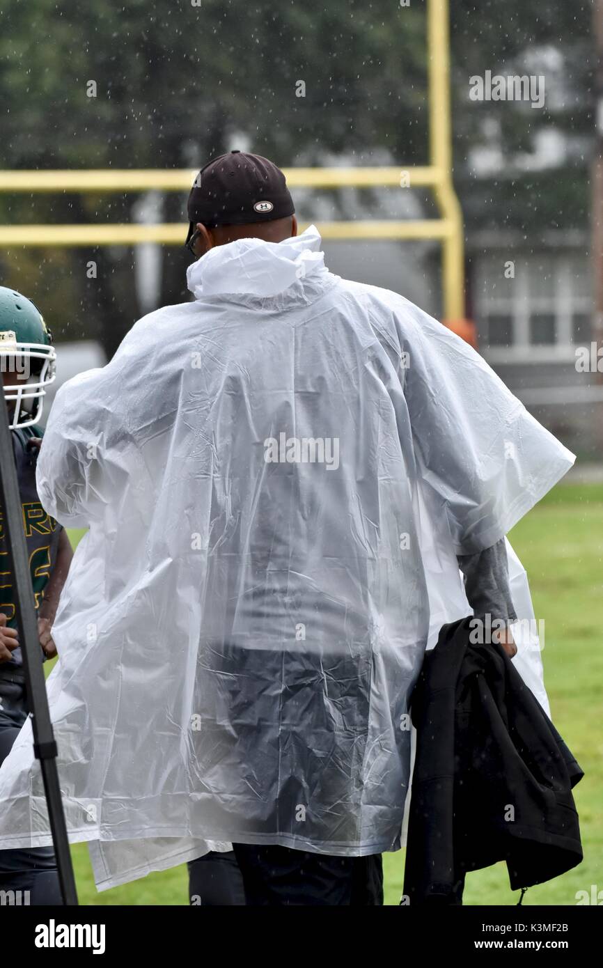 Fußball-Trainer tragen Poncho bei regnerischen Spiel Stockfoto