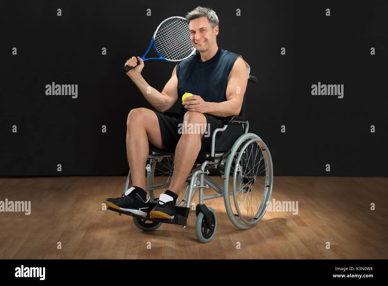 Behinderte Menschen im Rollstuhl mit Schläger und Ball Stockfoto