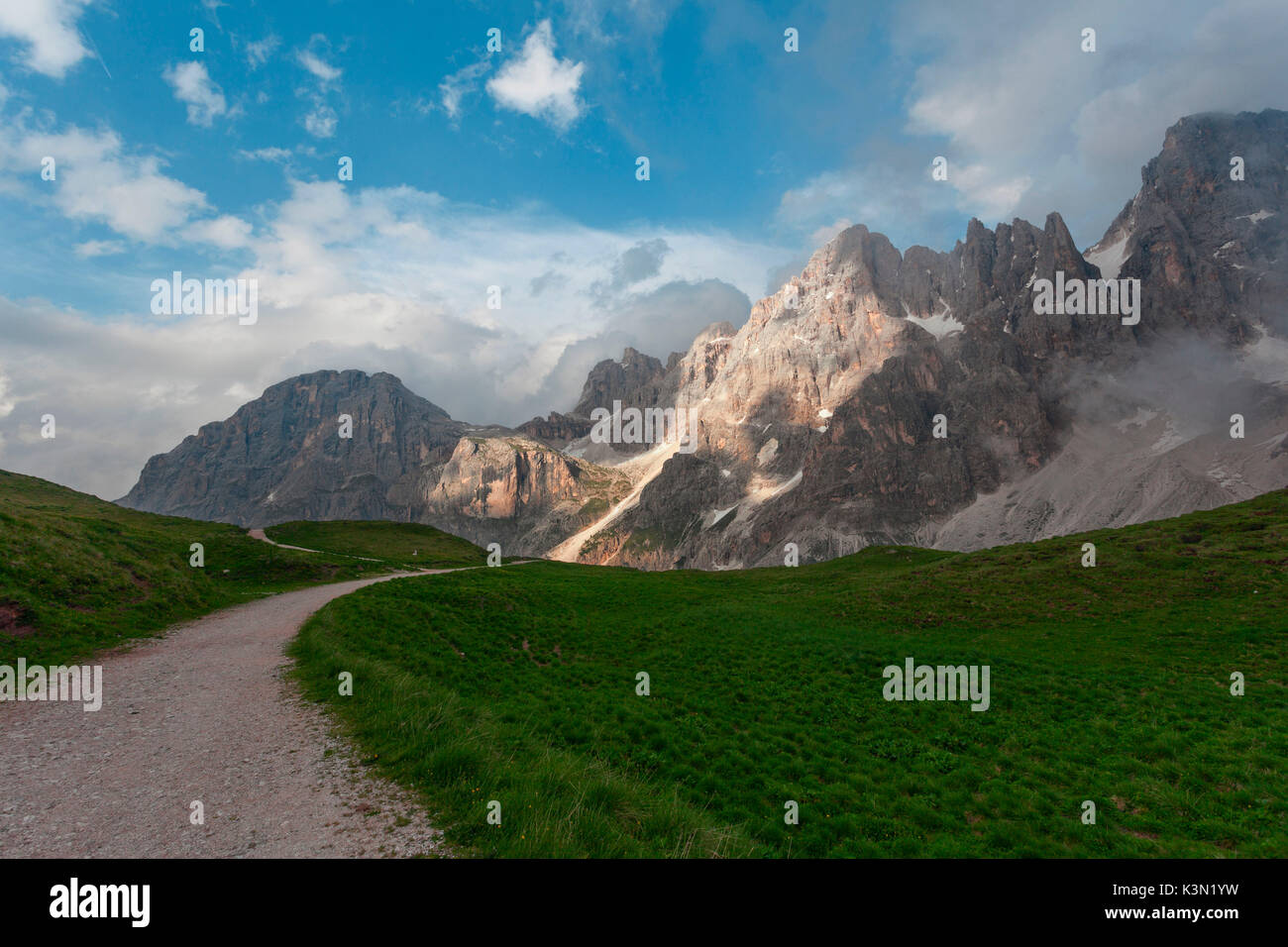 Weg durch die Wiesen in der Nähe der Baita Segantini. Im Hintergrund der Berg Mulaz und spiers der Pale di San Martino. Dolomiten, Pala Gruppe, Rolle. Stockfoto