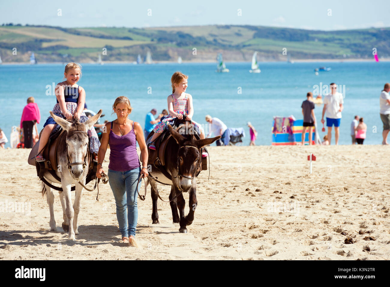 Kinder, Eselreiten am Strand von Weymouth, Dorset, Großbritannien. Stockfoto