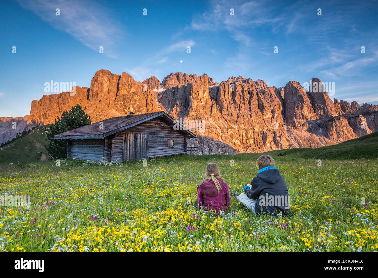 Passo Gardena, Dolomiten, Südtirol, Italien. Kinder bewundern Sie die alpenglühen auf die Berge der Sella Stockfoto