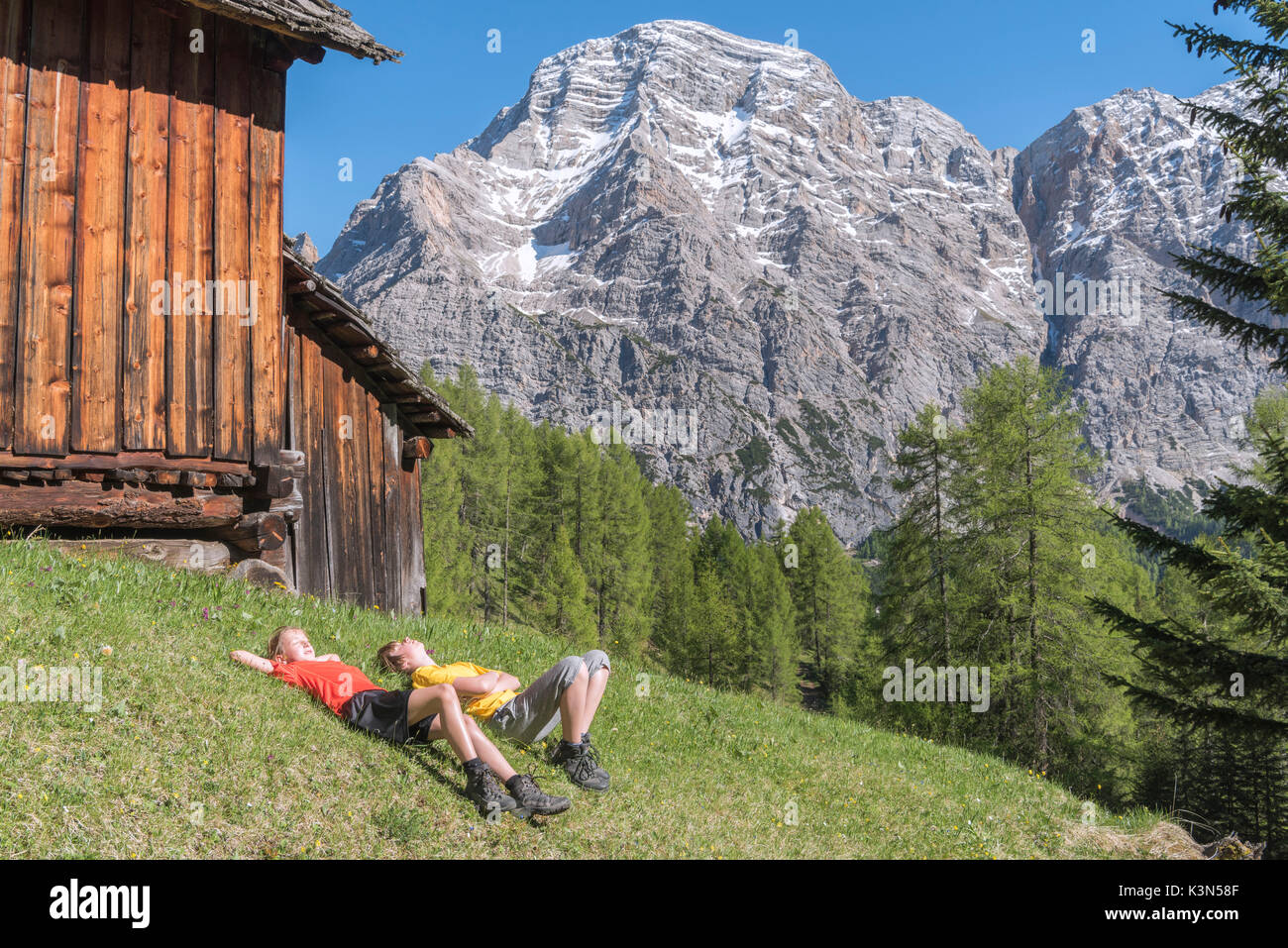 La Valle/ Wengen, Alta Badia, Provinz Bozen, Südtirol, Italien. Kinder auf den Weiden von Pra De Rit entspannen Stockfoto