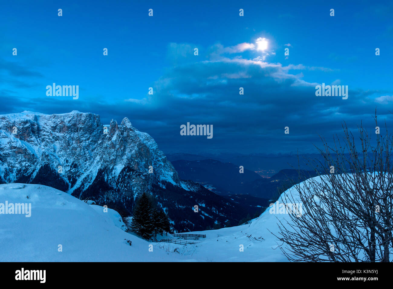 Seiser Alm, Dolomiten, Südtirol, Italien. Blaue Stunde auf der Hochebene von bullaccia/Puflatsch. Im Hintergrund der Gipfel des Schlern und die Lichter der Stadt Bozen Stockfoto