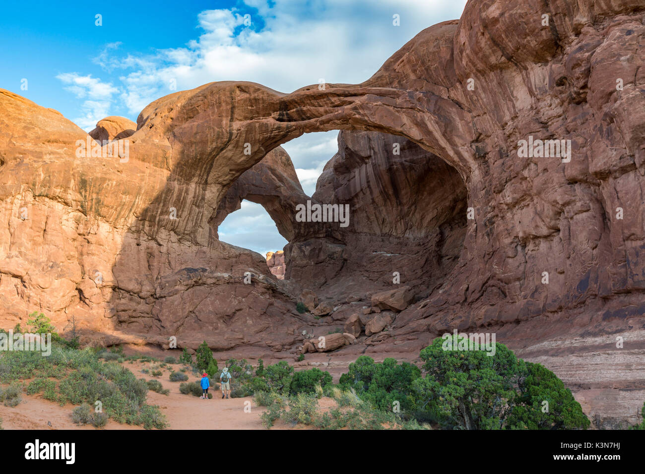 Zwei Leute vor Double Arch. Arches National Park, Moab, Grand County, Utah, USA. Stockfoto