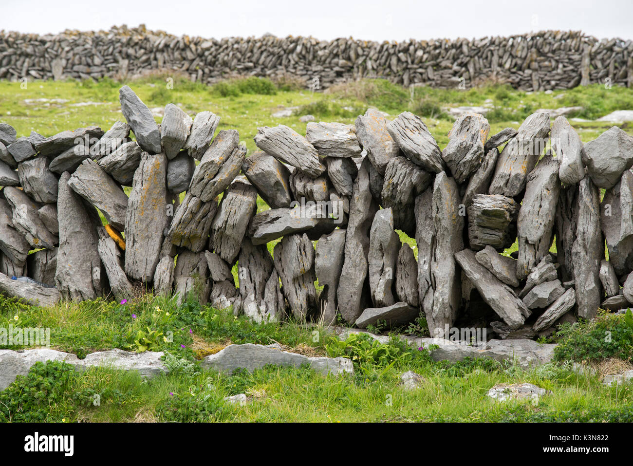 Felsen bilden eine Trockenmauer auf Grenzen des Landes in der Grafschaft Clare, Irland, Europa markieren. Stockfoto
