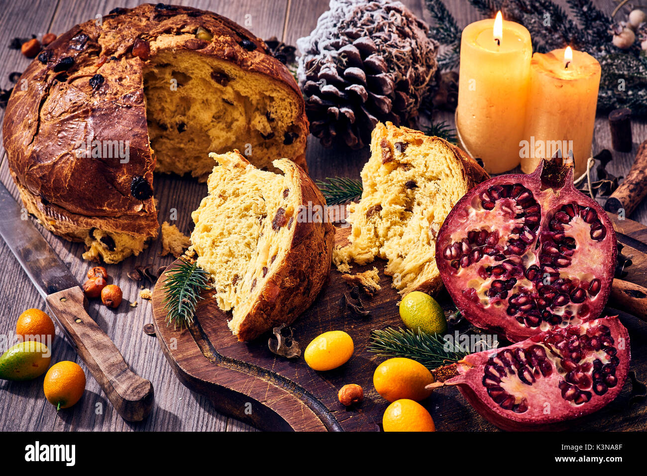 Traditionelle italienische Weihnachtskuchen mit Kerzen, Granatapfel und Winter Früchte, Panettone Stockfoto