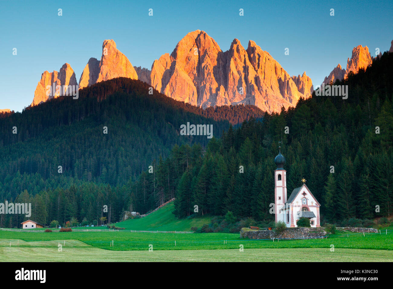 Funes Tal, Dolomiten, Trentino Alto Adige, Italien. Die malerische kleine Kirche San Giovanni in Ranui unterhalb der Geisler bei Sonnenuntergang. Stockfoto