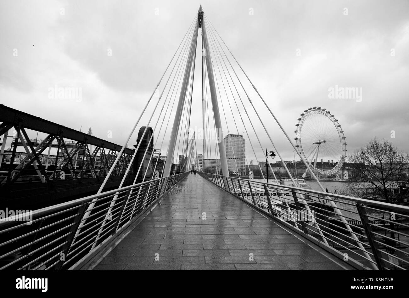 Der Golden Jubilee Bridge verfügt über eine moderne Architektur erinnert an die Dreiecke und auf der linken Seite das London Eye, an einem Tag mit Regen. London, England, Europa. Stockfoto