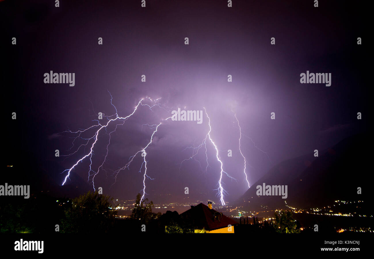 Ein starkes Gewitter viele Blitze auf dem Meran Stadt entladen, während der Nacht. Passeiertal, Trentino-Südtirol, Italien Stockfoto