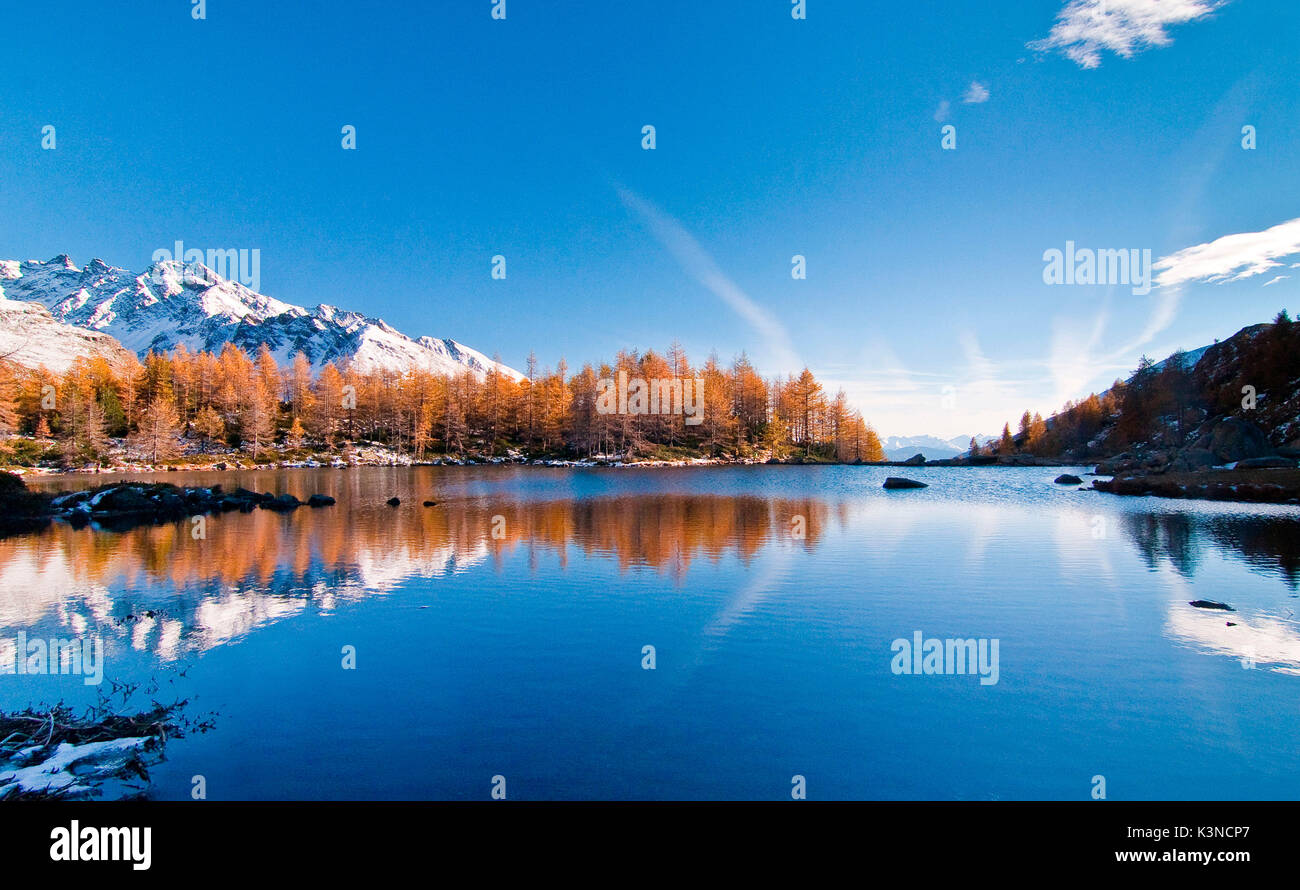 Alpin See im Herbst zwischen orange Lärche bei Sonnenuntergang Stockfoto