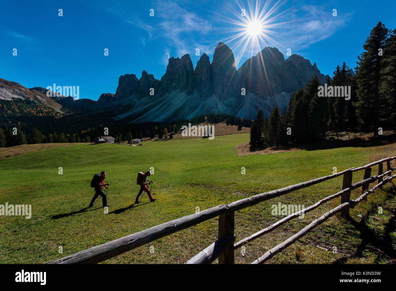 Geisler, Funes, Dolomiten, Trentino Alto Adige, Italien Zwei Wanderer fotografiert, wie Sie durch das Tal unterhalb der Geisler übergeben. Im Vordergrund ein Zaun Stockfoto
