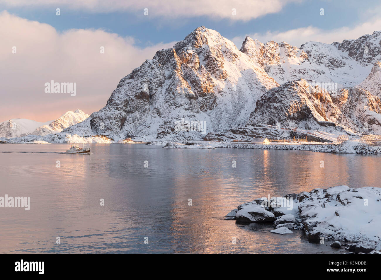 Angeln Boot segeln durch den eisigen Gewässern der Henningsvær Fischerdorf, Lofoten, Norwegen Stockfoto