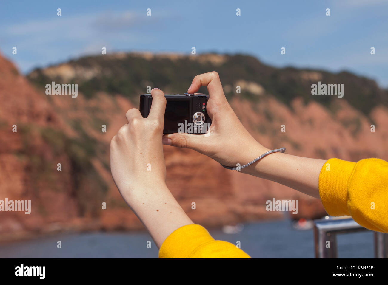 Ein paar Hände, die Bilder von einem Meer Kliff mit einer digitalen Kamera. Stockfoto