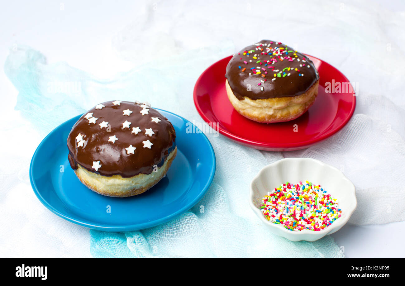 Hausgemachte dekoriert Donuts auf der bunten Platten auf Weiß Stockfoto