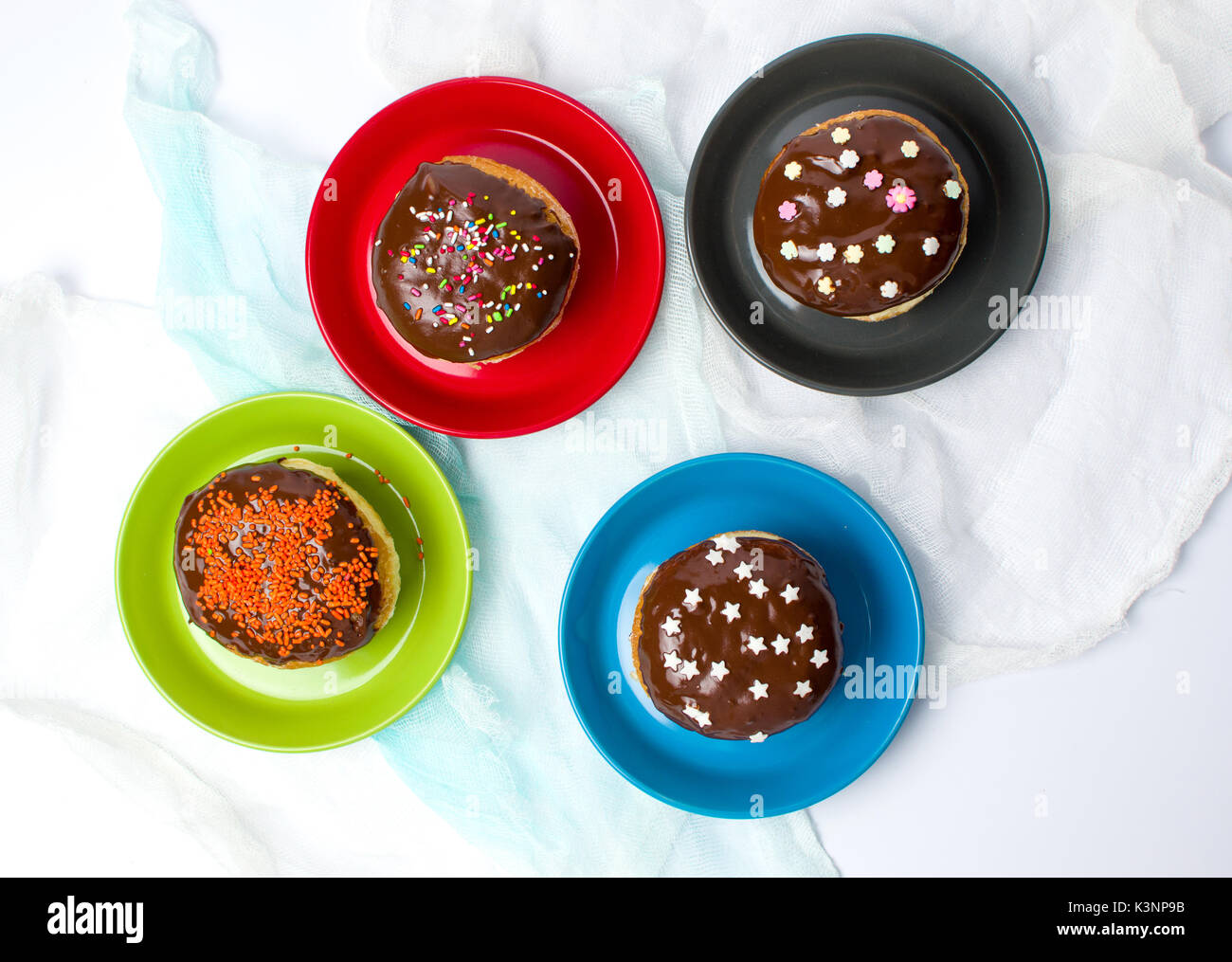 Dekoriert Donuts auf der bunten Platten Draufsicht Stockfoto