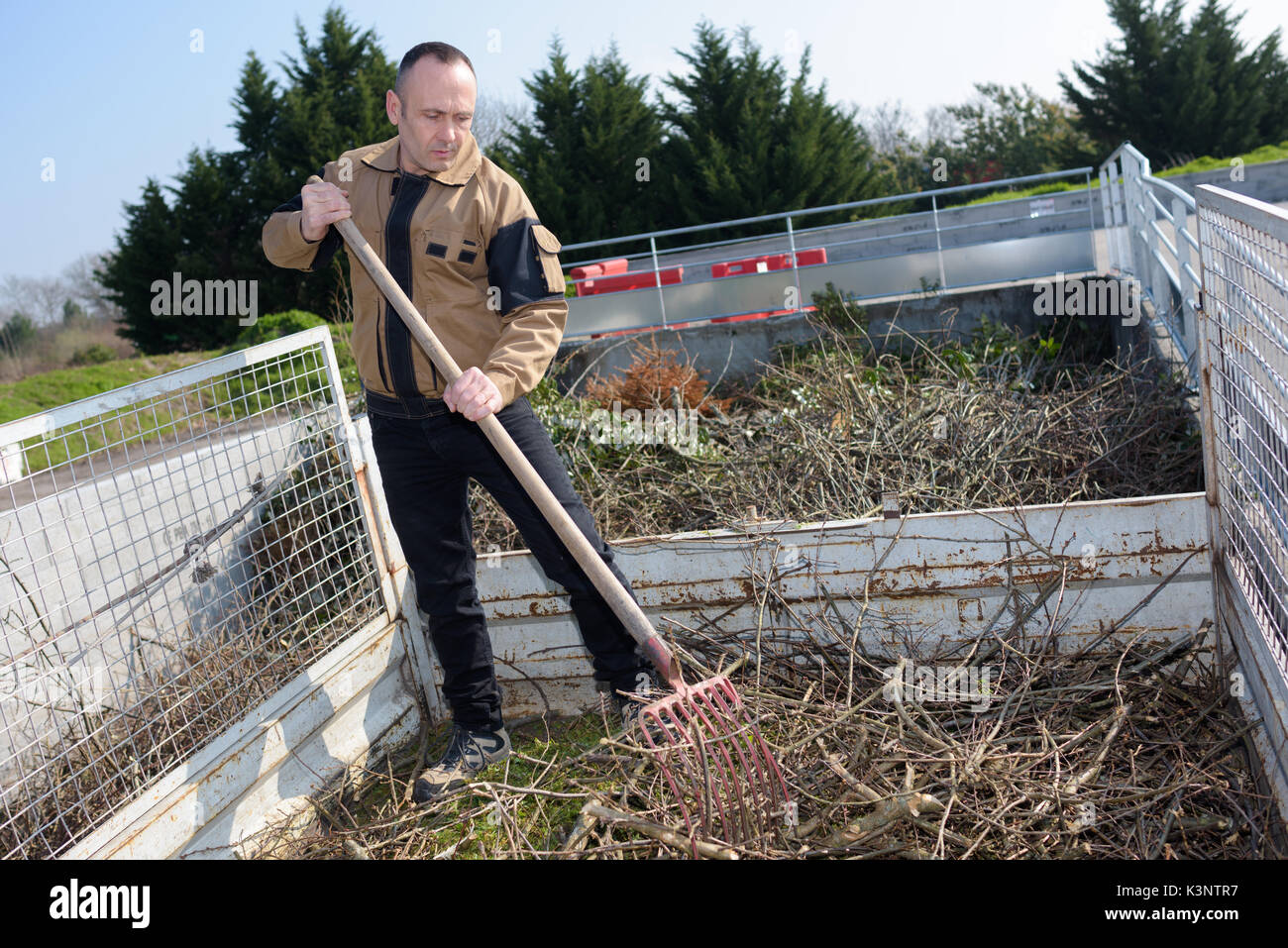 Landwirt harken getrocknete Zweige der Herbst Stockfoto