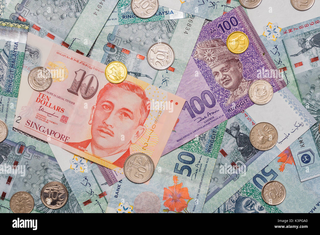 Singapur Dollar und -Münzen auf der Oberseite des Malaysischen Ringgit Währung auf Muster Hintergrund, Malaysische Ringgit Symbol ist RM Währungscode MYR, Singapur Dol Stockfoto