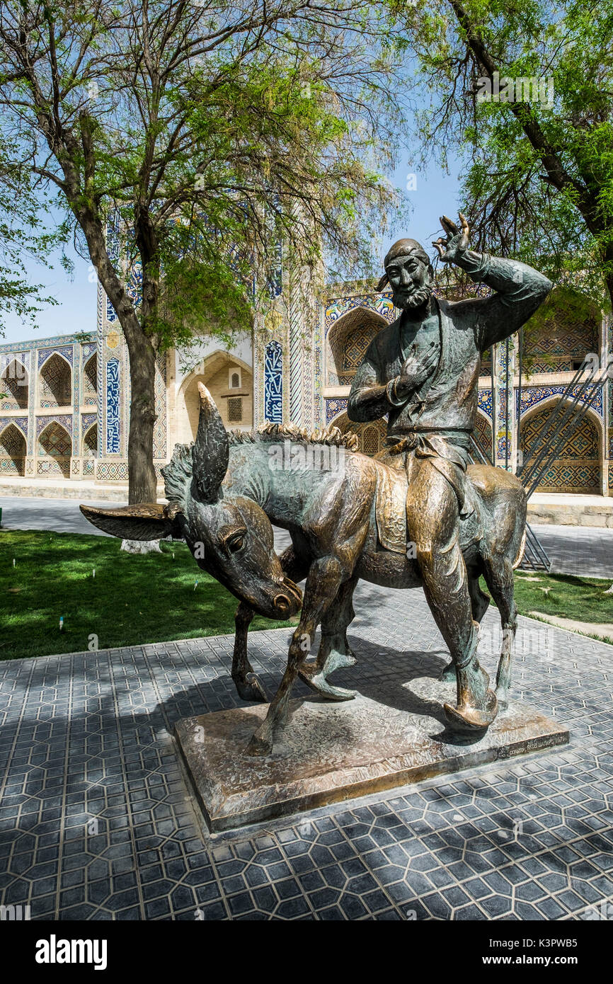Buchara, Usbekistan, in Zentralasien. Das Denkmal zu Nasreddin Hodscha und der Nadir Divan-Beghi madrasah im Hintergrund. Stockfoto