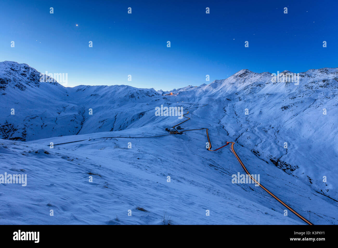Blaues Licht der Dämmerung auf die verschneite Landschaft und die Serpentinen des Stilfser Joch Braulio Tal Veltlin Lombardei Italien Europa Stockfoto