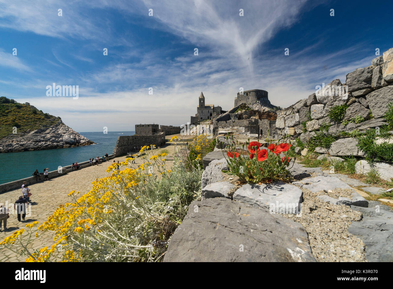 Blumen und blaues Meer umrahmen das alte Schloss und San Pietro Kirche Portovenere Provinz von La Spezia Ligurien Italien Europa Stockfoto