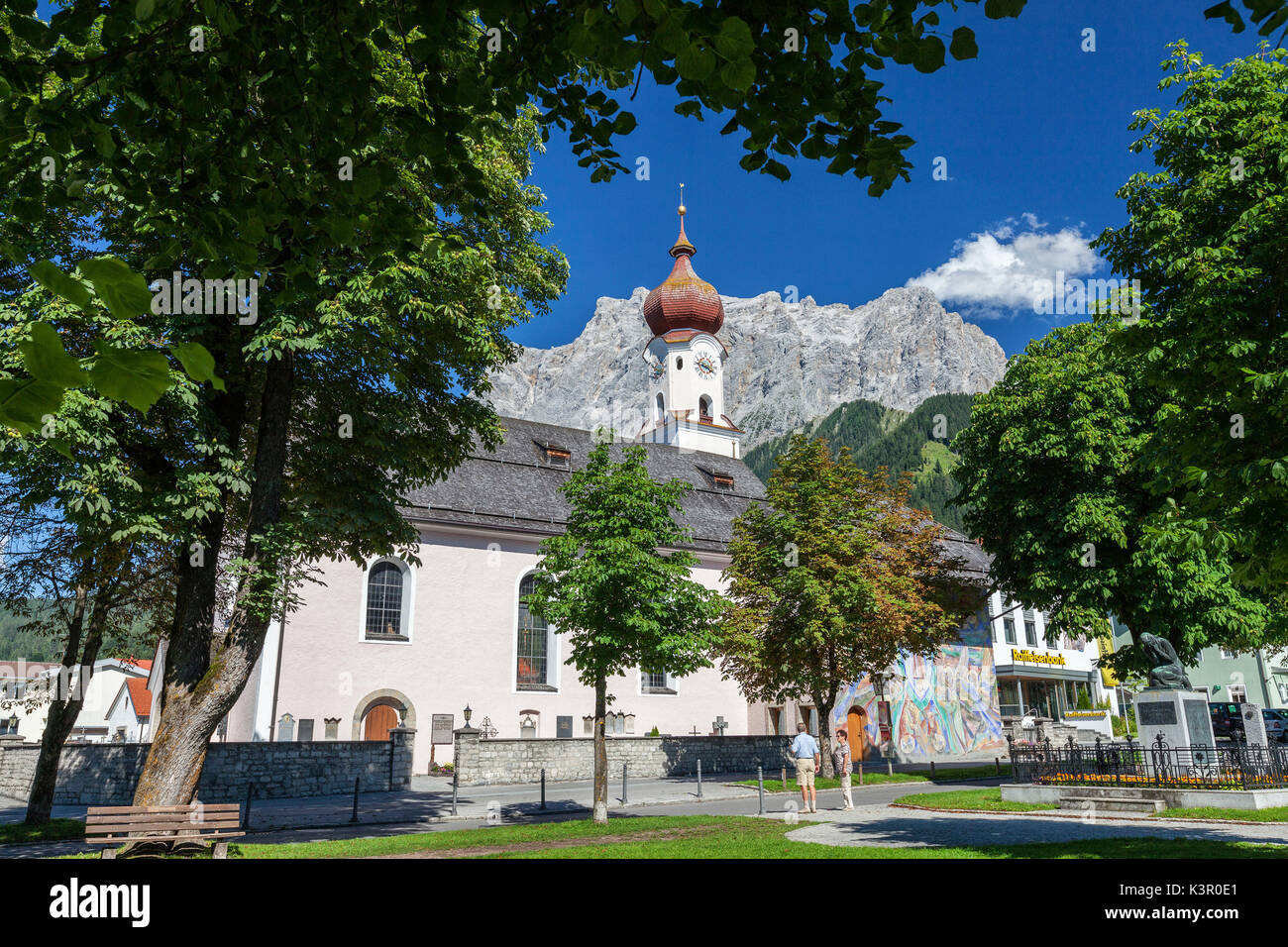 Typische Kirche alpinen Dorfes umgeben von Gipfeln und Wald Garmisch Partenkirchen Oberbayern Region Bayern Deutschland Europa Stockfoto