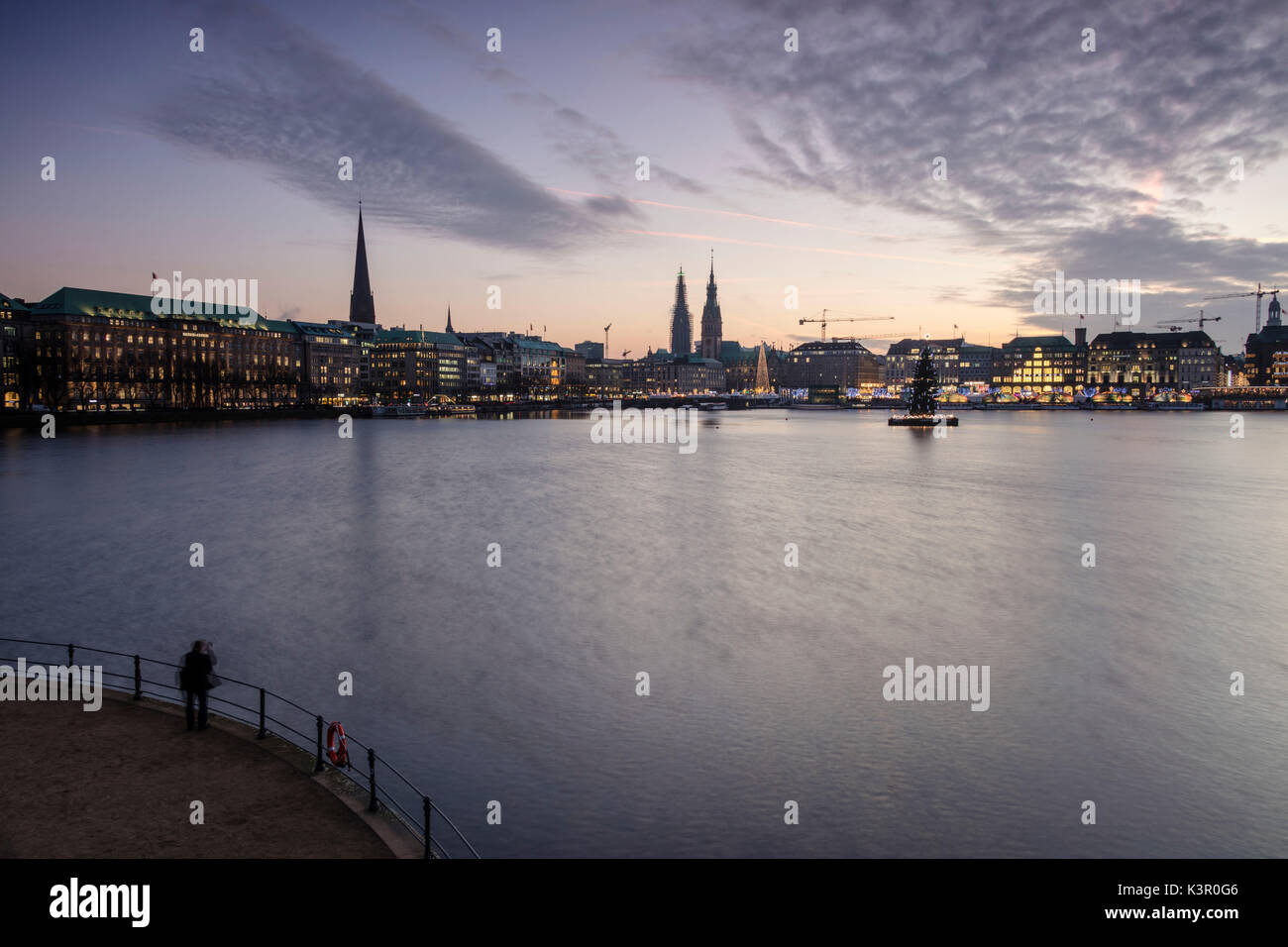 Fotograf bewundert die Binnenalster mit den Weihnachtsbaum im Wasser in der Dämmerung Hamburg Deutschland Europa ausgesetzt Stockfoto