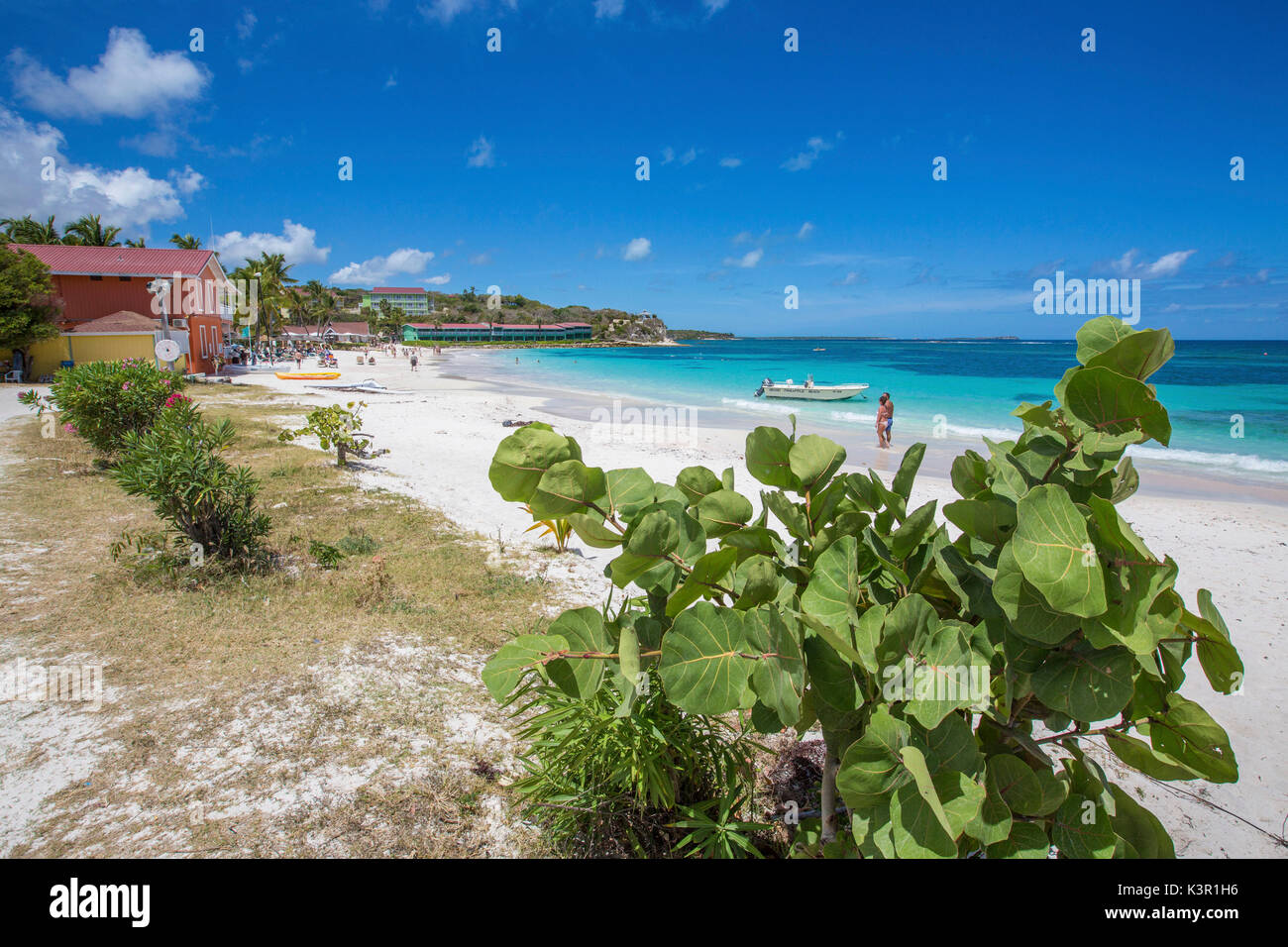 Weißer Sand und Touristen Frame das türkisblaue Karibische Meer an der Long Bay Beach Antigua und Barbuda Leeward Inseln Westindische Inseln Stockfoto