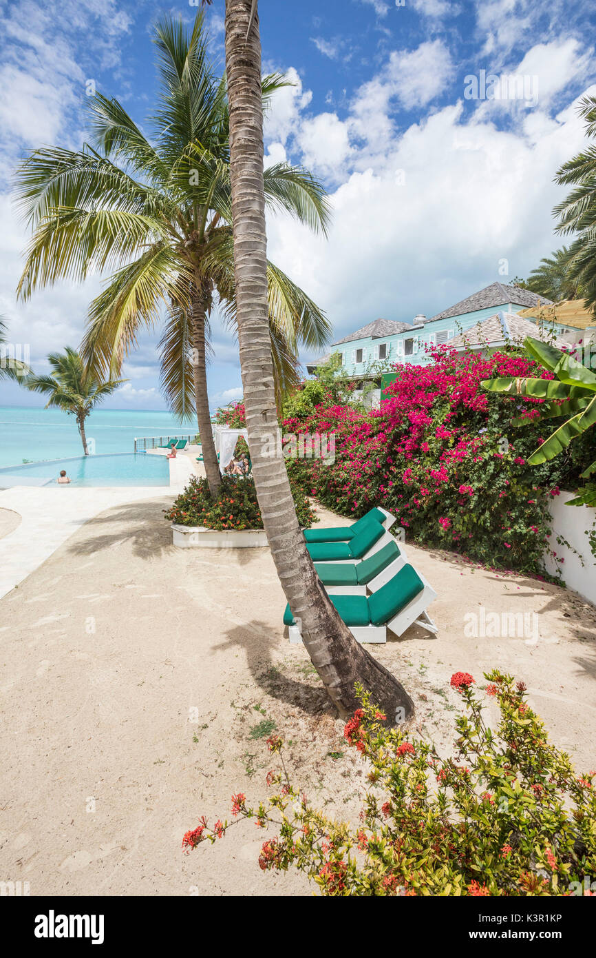 Liegestühle und Palmen mit Blick auf das Karibische Meer Ffryes Beach Felsen Antigua und Barbuda Leeward Island West Indies Stockfoto