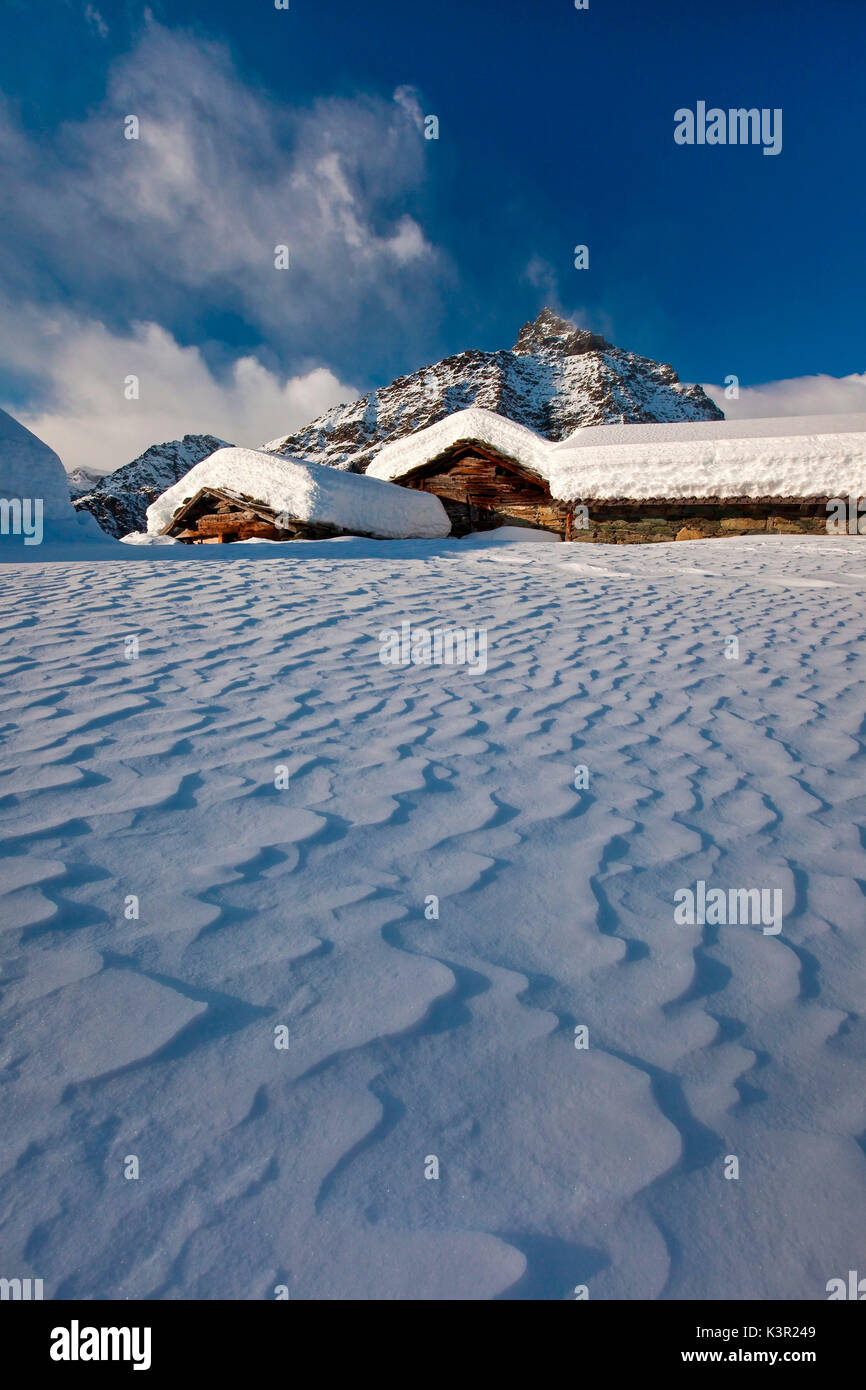 Der wind Formen der Schnee fiel zwischen den traditionellen Hütten der Alpe Prabello. Valmalenco. Valtellina in der Lombardei. Italien Europa Stockfoto