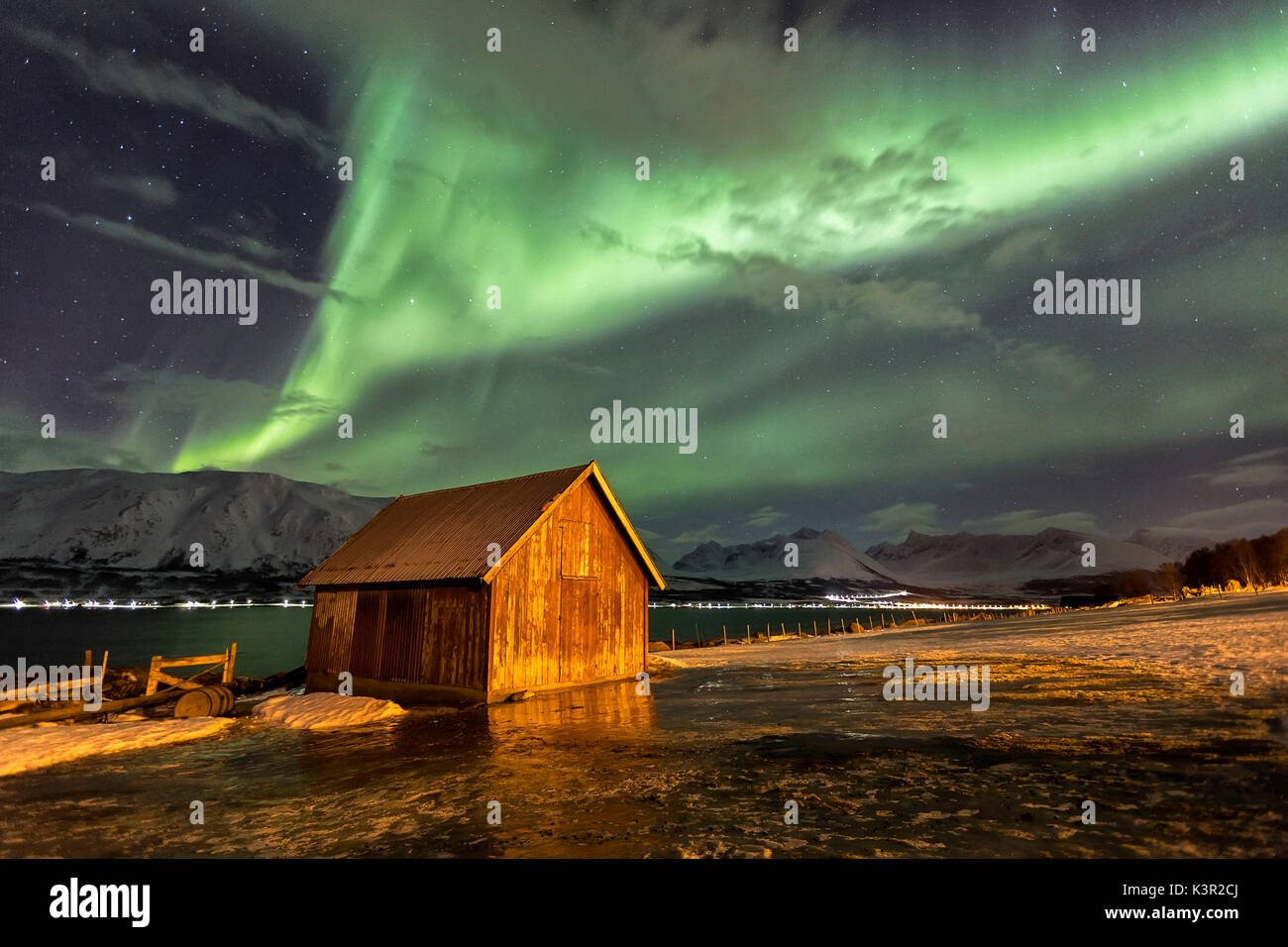 Nordlicht erhellt die Holzhütte am Lenangsoyra Lyngen Alpen Tromsø Lappland Norwegen Europa Stockfoto