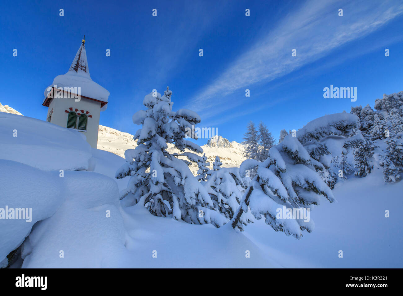 Der Glockenturm von Schnee umgeben von Wäldern Maloja Kanton Graubünden Engadin Schweiz Europa untergetaucht Stockfoto