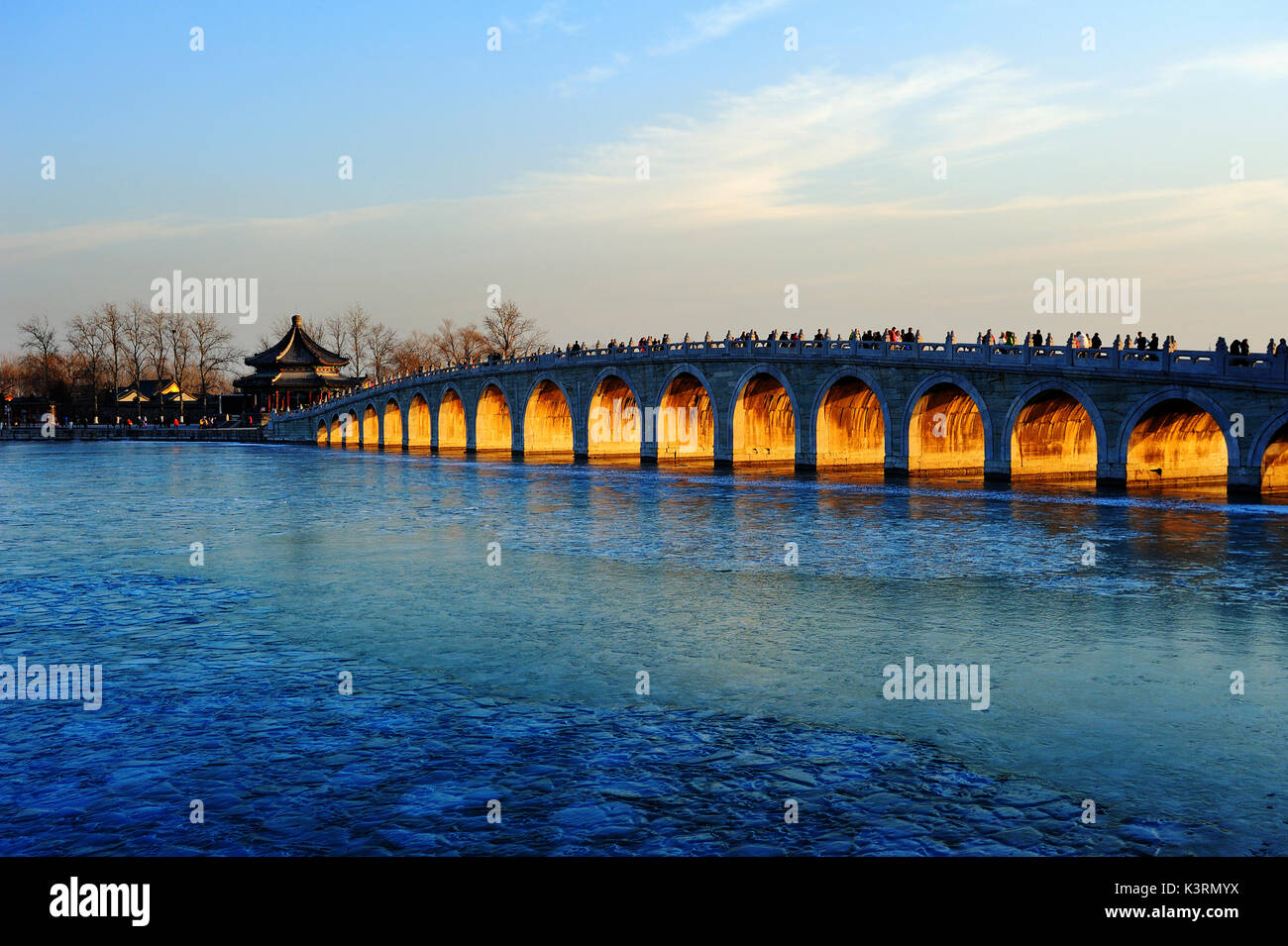 Der Sommerpalast im Winter, Kunming See wurde eingefroren, die Abendsonne durch die Brücke öffnen Der 17 Bogenbrücke. Stockfoto