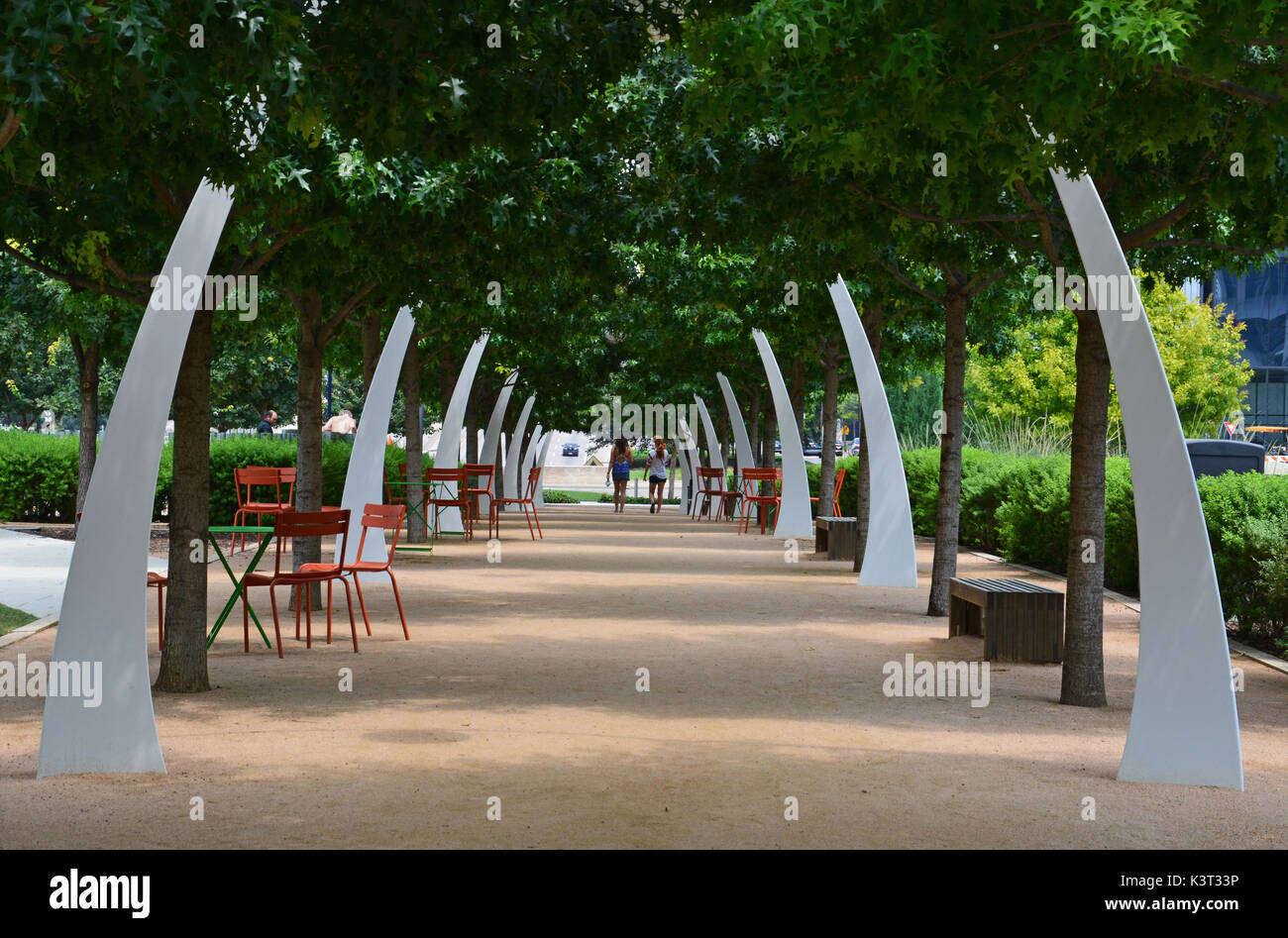 Die Eiche von Bäumen gesäumten Pfad am Klyde Warren Park in Dallas bietet Sitzgelegenheiten und dekorative Torbögen. Stockfoto