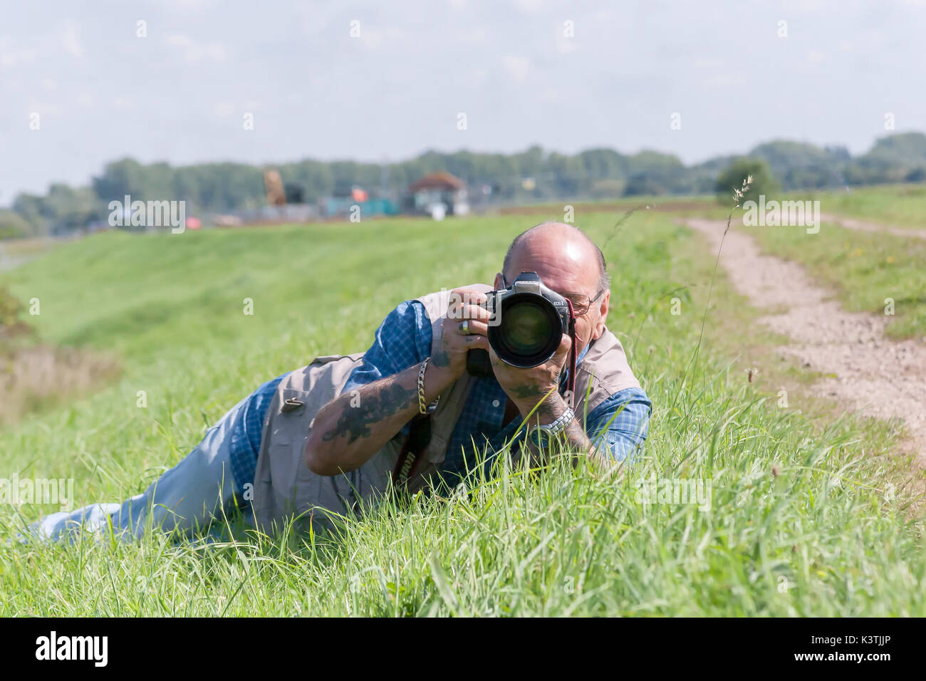 Männliche Festlegung auf ein Gras bank die Bilder mit einer Canon Kamera. Stockfoto