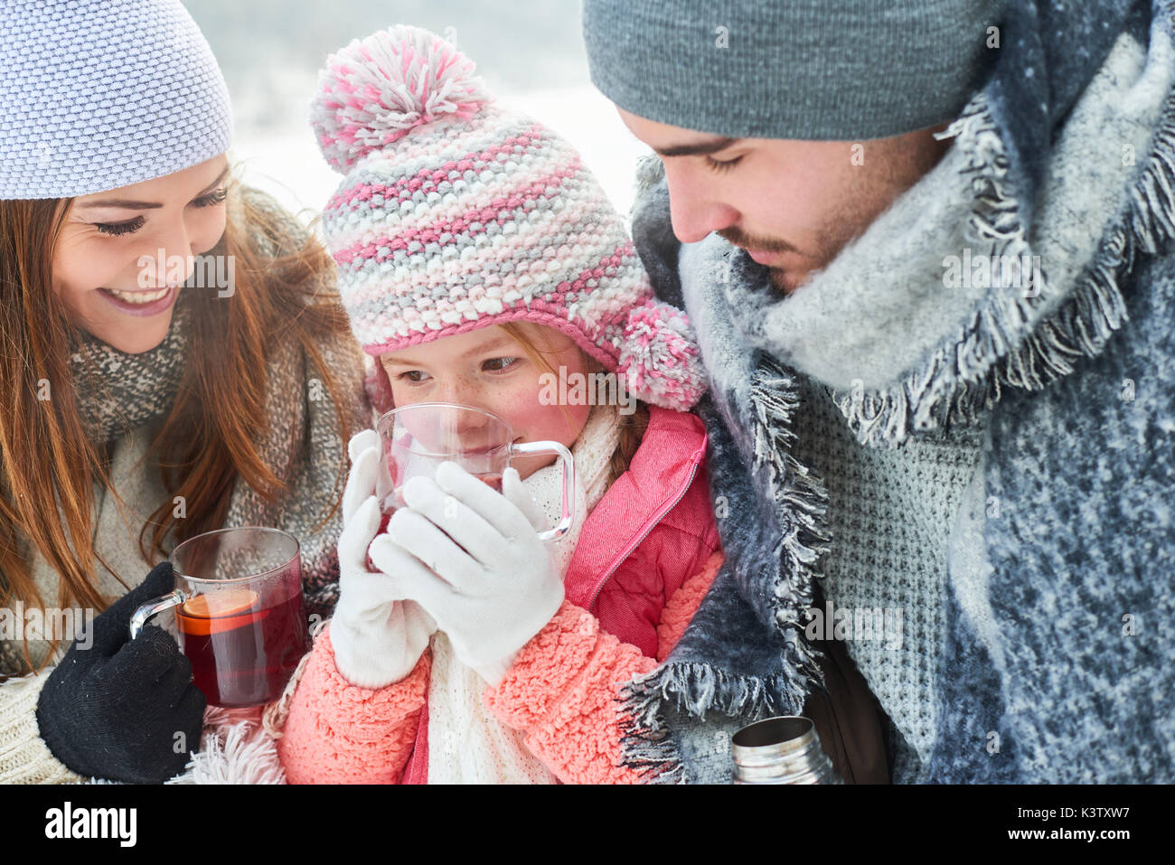 Eltern und Kind trinken Tee als Familie im Winter Stockfoto