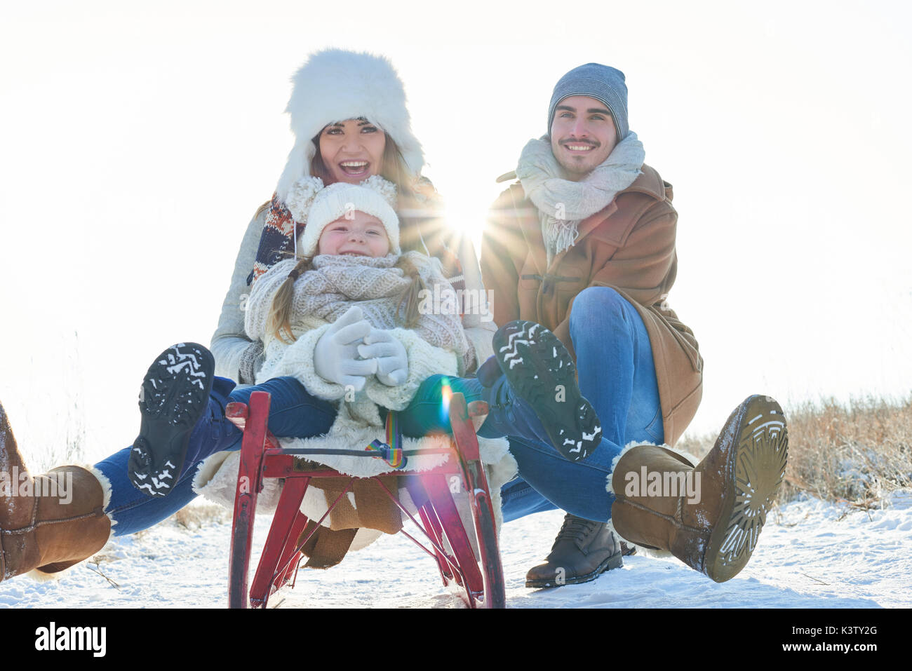 Familie mit Kind fahren Rodeln oder Schlitten im Schnee und Spaß haben Stockfoto