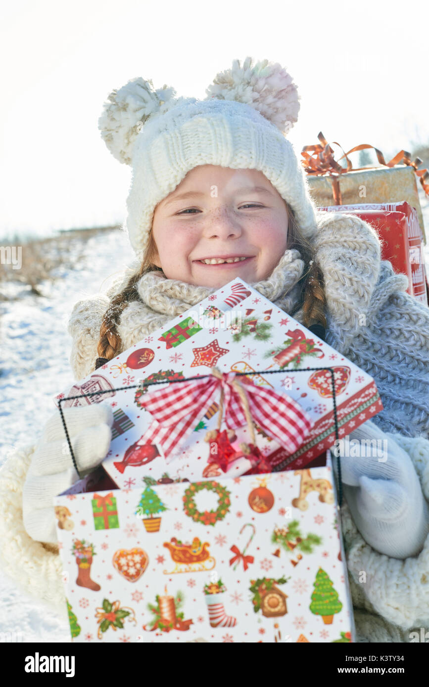 Glückliches Mädchen mit Weihnachtsgeschenk lächelnd mit Freude Stockfoto