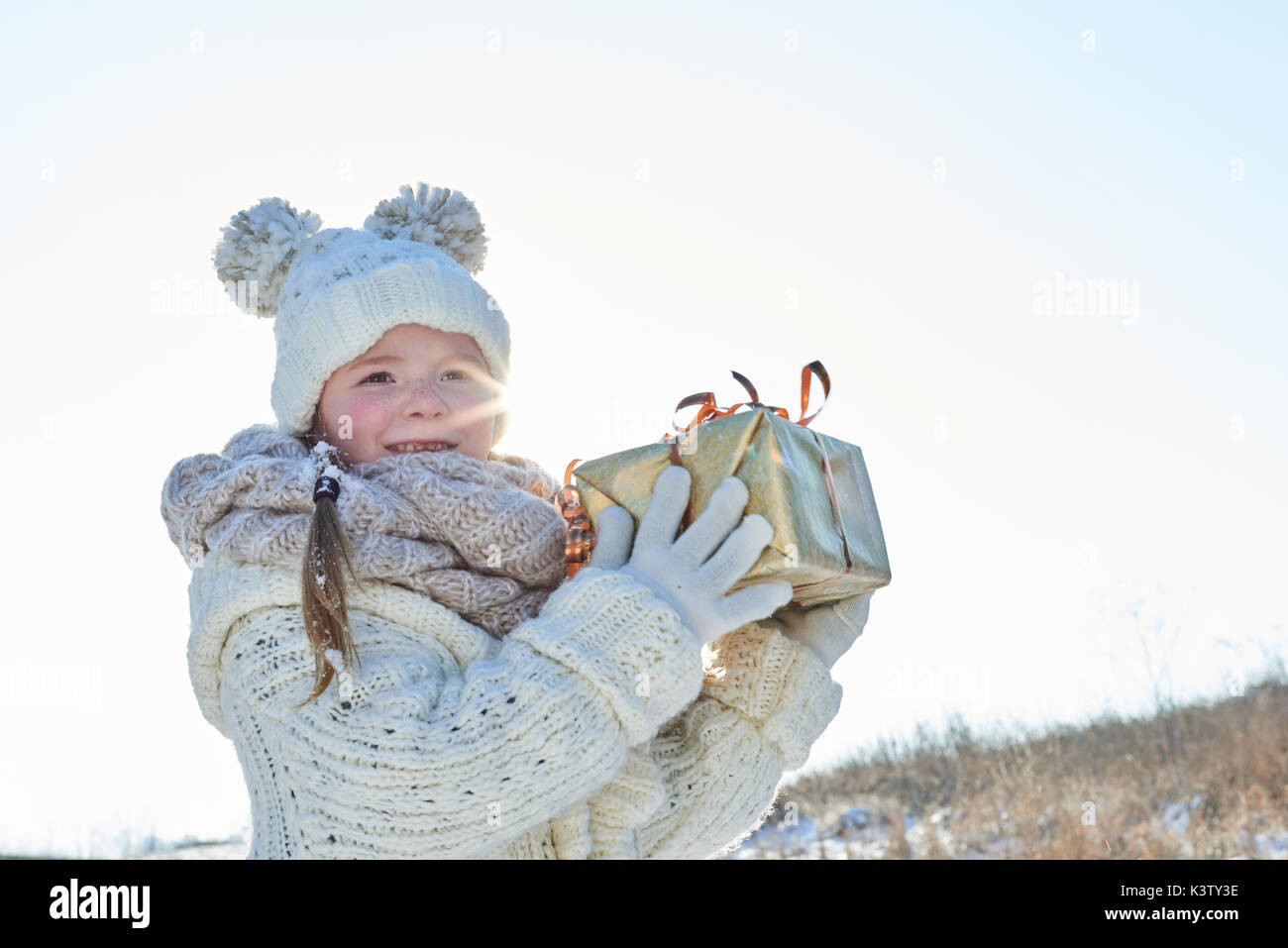 Kind hält Überraschung Weihnachtsgeschenk mit Freude Stockfoto