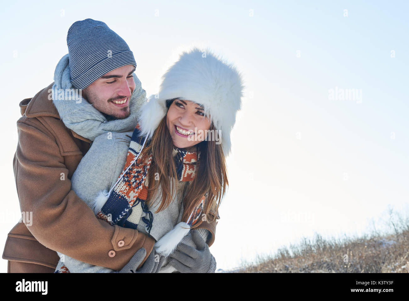 Glückliches Paar in der Liebe im Winter und Mann umarmt Freundin Stockfoto