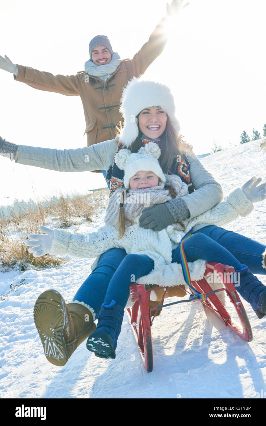 Familie haben Spaß im Schnee im Winter mit Schlitten Stockfoto