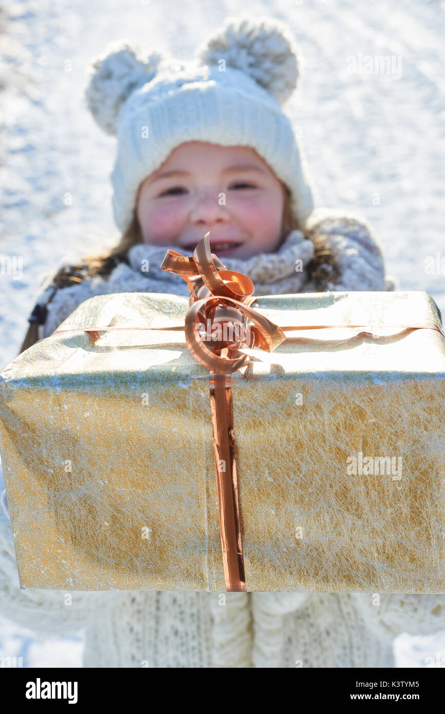 Kind spendet Weihnachtsgeschenk im Winter als Überraschung Stockfoto