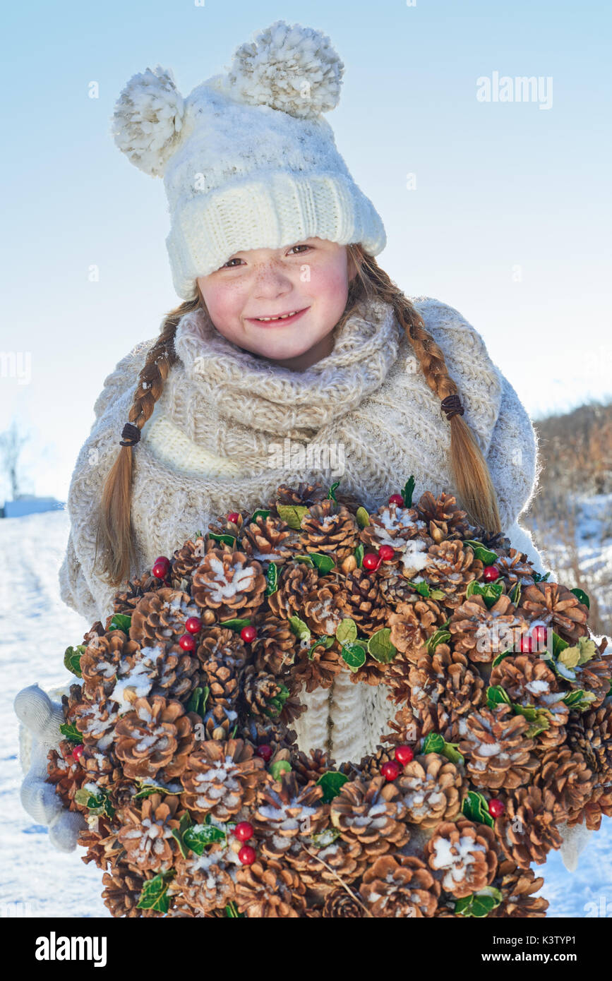 Mädchen halten Adventskranz für Weihnachten im Winter Stockfoto