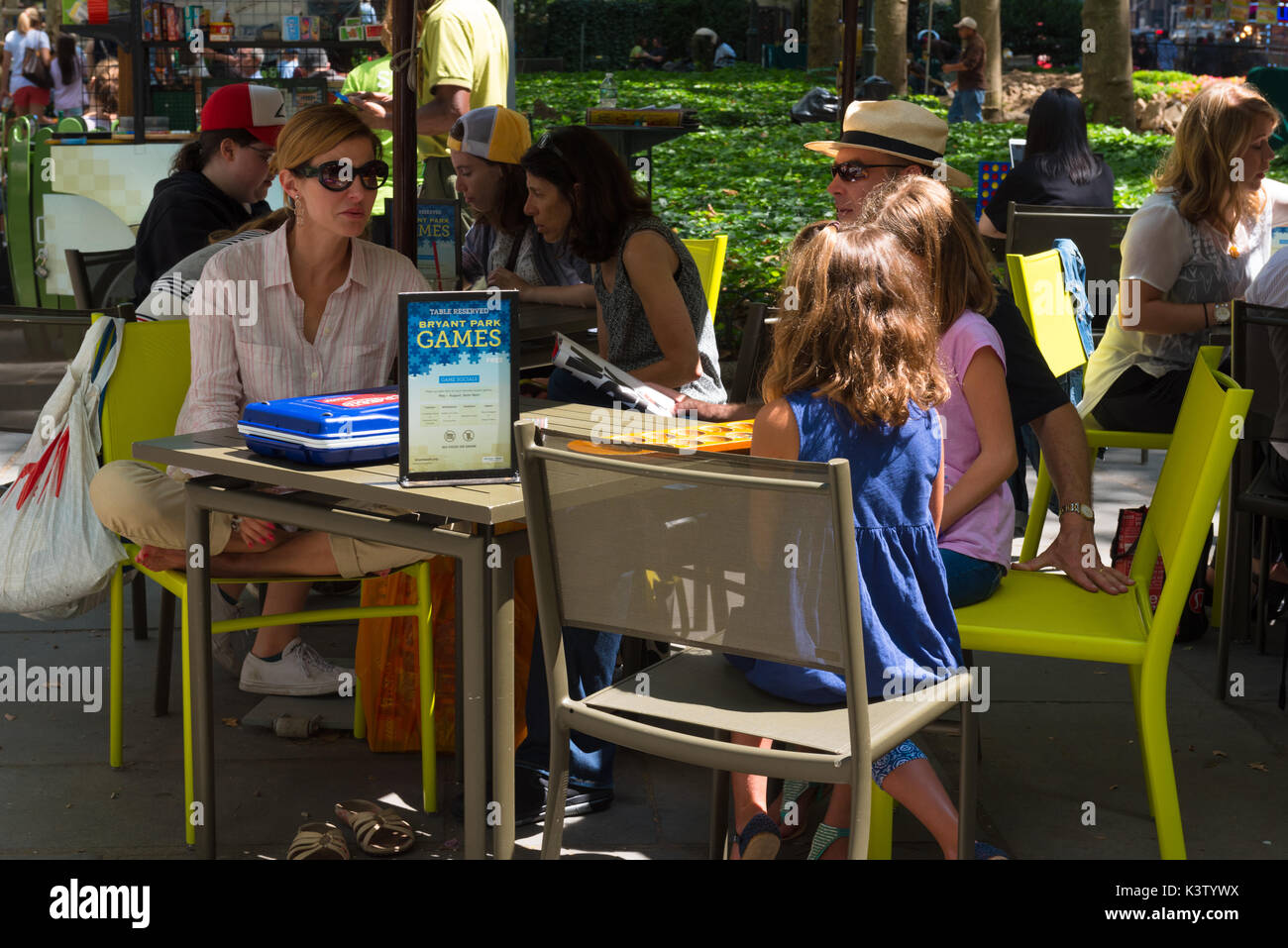 New York, NY, USA August 3, 2016 -- Menschen rund um die Spieltische im Bryant Park sitzen auf einem Sommertag in Manhattan. Redaktionelle Verwendung. Stockfoto